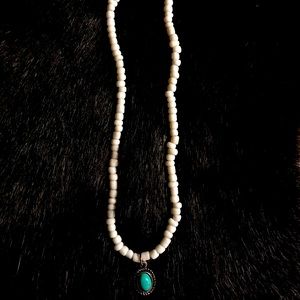 White necklace with a coral blue charm